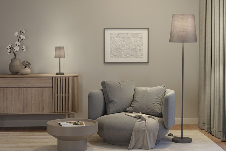 Wohnzimmer mit Sessel, Stehlampe, Tischlampe, Sideboard und Dekoration