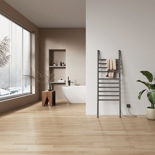 Modernes Badezimmer mit freistehender Badewanne, wandhängendem Handtuchheizkörper, Holzboden und Fenster mit Jalousien in heller Umgebung.