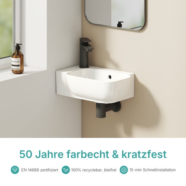 Waschtisch mit Armatur und Spiegel im Badezimmer.