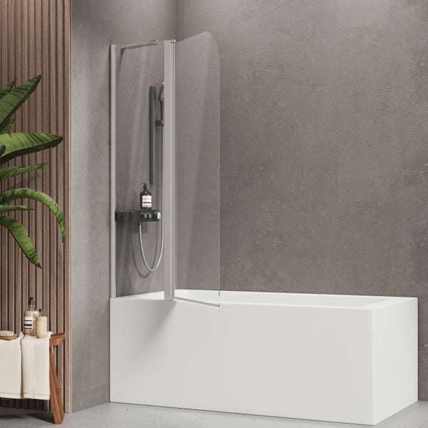 Moderne Badewannenfaltwand aus Glas mit Duschsystem in einem Badezimmer mit Betonoptik und Holzelementen.