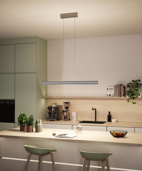 Moderne Küche mit einer schlanken, horizontalen Pendelleuchte über einer Kochinsel mit grünen Schränken und Arbeitsplatten in Holzoptik.