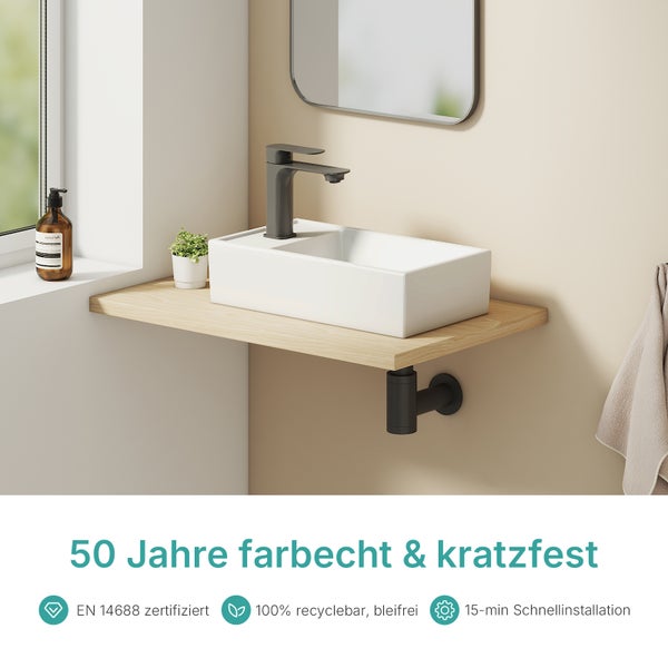 Waschtisch mit rechteckigem Waschbecken, Armatur und Spiegel in einem hellen Badezimmer.