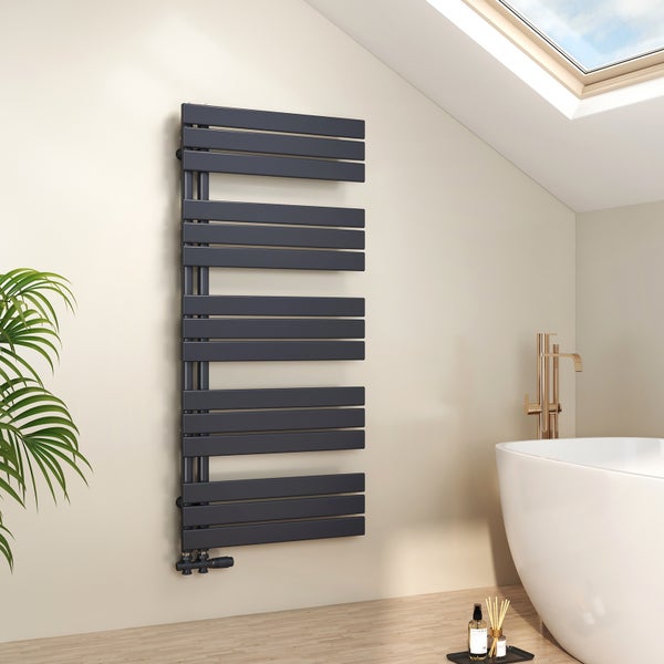 Anthrazitfarbener Handtuchheizkörper mit flachen horizontalen Paneelen an heller Wand im Badezimmer mit weißer Badewanne und goldener Armatur.