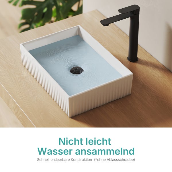Waschbecken aus Keramik mit Wasser und schwarzer Armatur