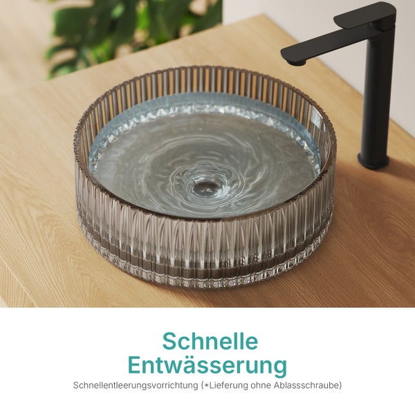 Aufsatzwaschbecken aus Glas mit Wasserhahn auf einer Holzoberfläche