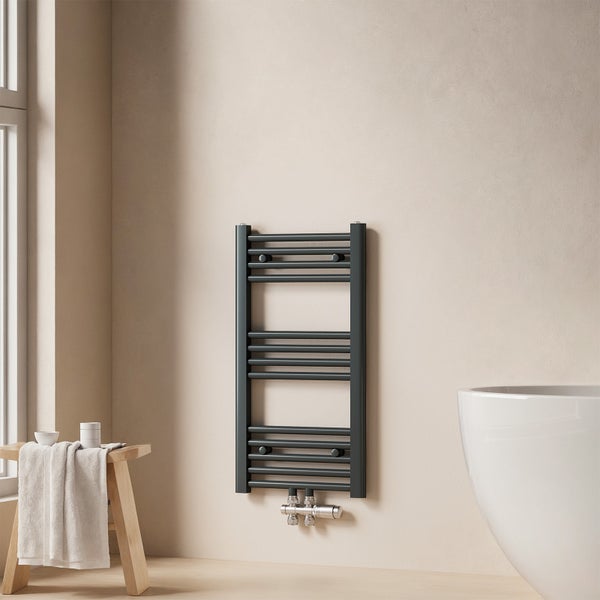 Grauer Badheizkörper an beiger Wand in einem Badezimmer