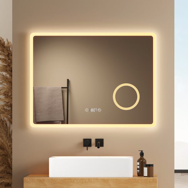 Badezimmer mit beleuchtetem Spiegel, Handtuch, Waschbecken und Armaturen