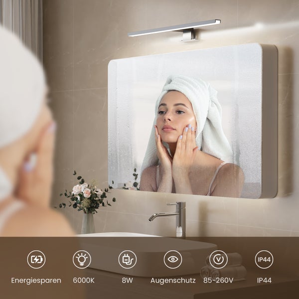 Badezimmer mit beleuchtetem Spiegel, Waschbecken und Armatur