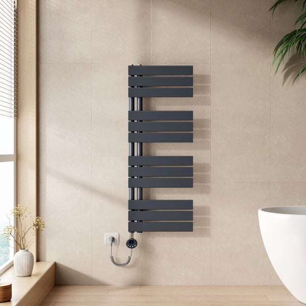 Elektrischer Handtuchheizkörper in Anthrazit mit asymmetrischen Flachrohren an einer hellen Fliesenwand im modern gestalteten Badezimmer.