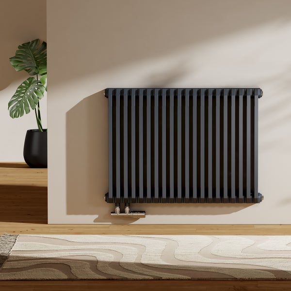 Grauer Heizkörper an der Wand in einem hellen Raum.