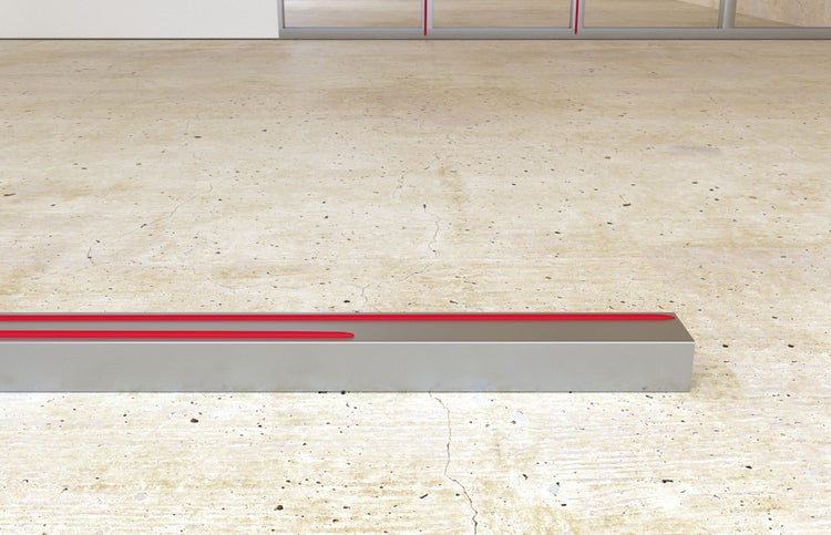 Bodeneinbauleuchte aus Metall mit Lichtlinien auf Betonboden