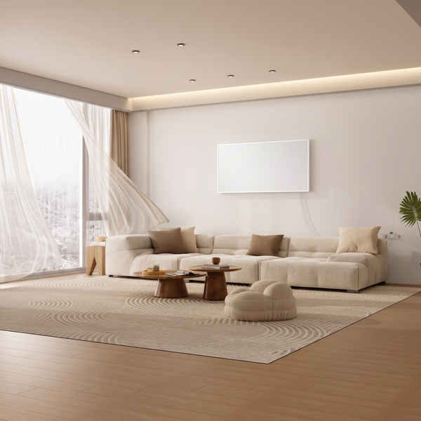 Modernes Wohnzimmer mit großer Couch, zwei Couchtischen und einer Infrarotheizung an der Wand vor einem großen Fenster mit wehenden Gardinen.