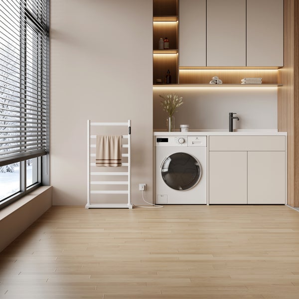 Moderne Waschküche mit Waschmaschine, Einbauschränken, beleuchteten Regalen, Handtuchheizkörper und Holzboden vor einem Fenster mit Jalousien.