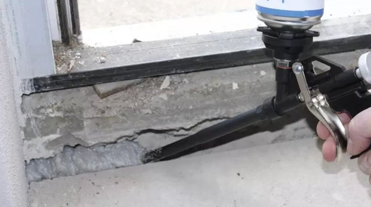 Schaumpistole im Einsatz zum Abdichten eines Fensters.
