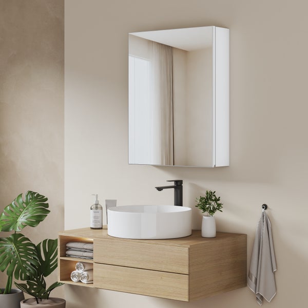 Moderner Waschtisch aus hellem Holz mit weißem Aufsatzbecken, schwarzer Armatur und einem darüber hängenden Spiegelschrank.