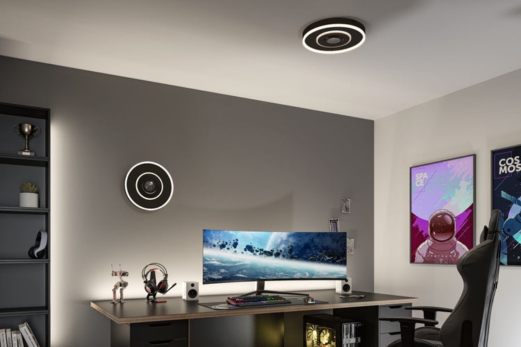 Modernes Gaming-Zimmer mit runden LED-Leuchten an Wand und Decke, einem großen Curved-Monitor auf dem Schreibtisch und einem Gaming-Stuhl.