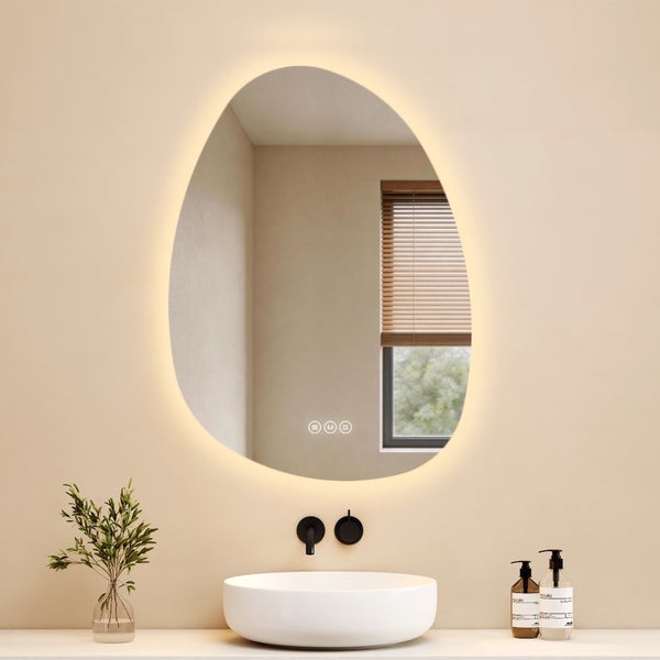 Asymmetrischer Badezimmerspiegel mit LED-Licht und Touch-Sensoren über einem weißen Aufsatzwaschbecken in einem modernen Badezimmer.