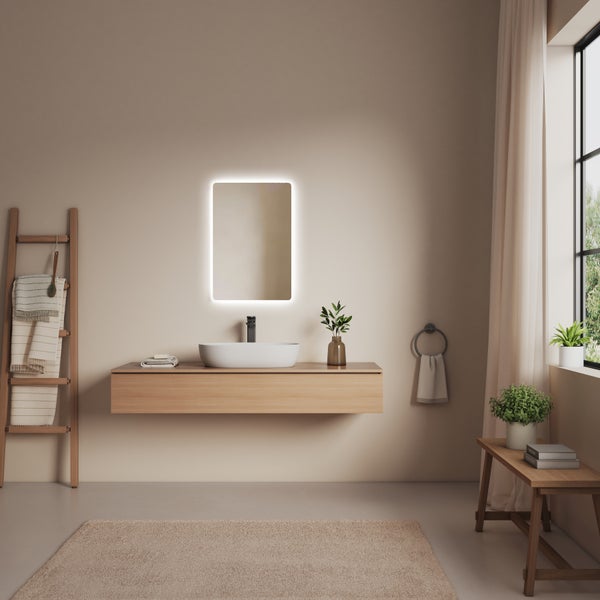 Helles Badezimmer mit Waschtisch, Spiegel mit Beleuchtung und Holzleiter mit Handtüchern.