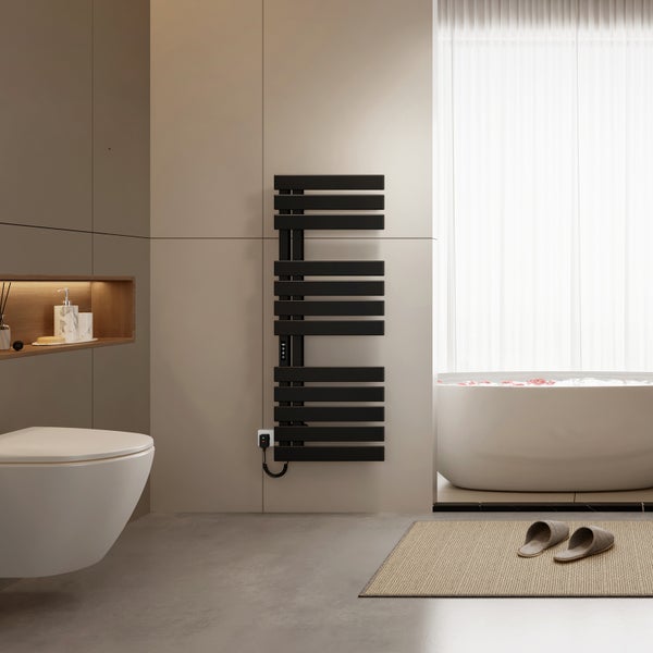 Modernes Badezimmer mit schwarzem elektrischem Handtuchheizkörper, Wand-Toilette, freistehender Badewanne und beigefarbenen Fliesen.