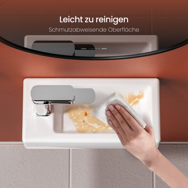 Hand reinigt Waschbecken mit schmutzabweisender Oberfläche