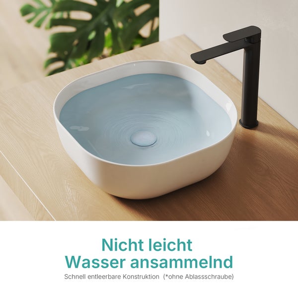 Quadratisches Aufsatzwaschbecken mit abgerundeten Ecken, mit Wasser gefüllt, auf einer Holzplatte neben einer hohen, mattschwarzen Armatur.