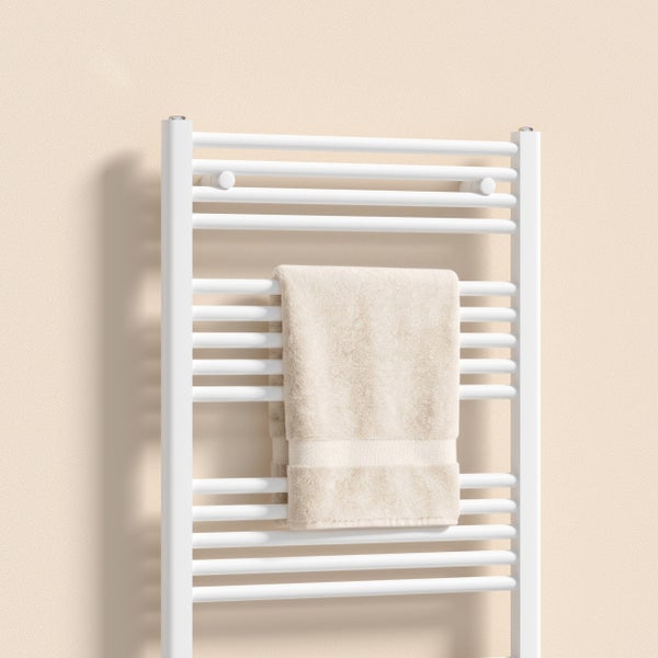 Weißer Badheizkörper mit beigem Handtuch
