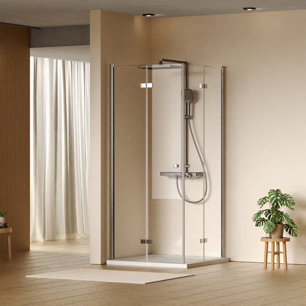 Eckdusche mit Duscharmatur und Glaswänden in einem Badezimmer.