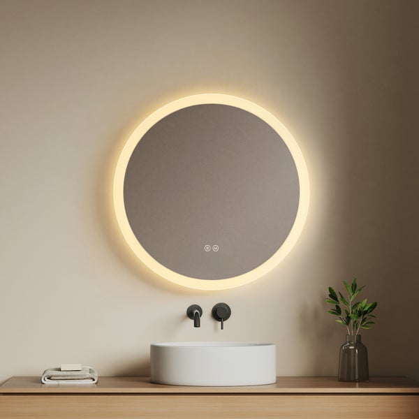 Runder LED-Badezimmerspiegel mit Leuchtring, Wandarmatur, weißes Aufsatzbecken auf Holzunterschrank, moderner minimalistischer Stil.