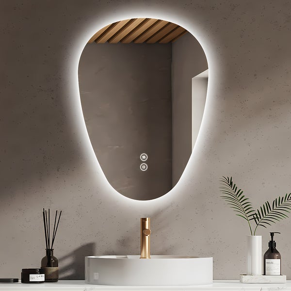 Tropfenförmiger Badezimmerspiegel mit LED Beleuchtung und Touch Steuerung über einem runden Waschbecken mit goldfarbener Armatur.