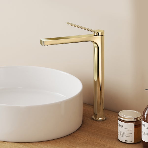 Goldene Waschtischarmatur neben einem runden Waschbecken