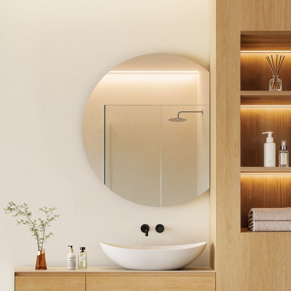 Modernes Badezimmer mit rundem Wandspiegel, Aufsatzwaschbecken und beleuchtetem Holzregal in einer hellen, minimalistischen Umgebung.