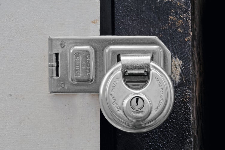 ABUS Diskus Vorhangschloss mit Überfalle aus Edelstahl an einer Tür.