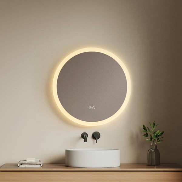 Runder Badezimmerspiegel mit LED Beleuchtung über weißem Aufsatzwaschbecken und schwarzer Wandarmatur auf einem Waschtisch aus Holz.