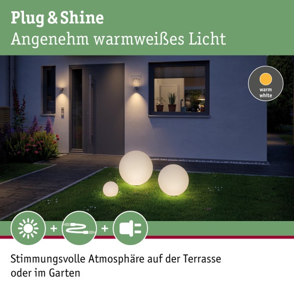 Drei beleuchtete Kugelleuchten auf einer Rasenfläche vor einem Haus mit warmweißem Licht für eine stimmungsvolle Atmosphäre auf der Terrasse oder im Garten.