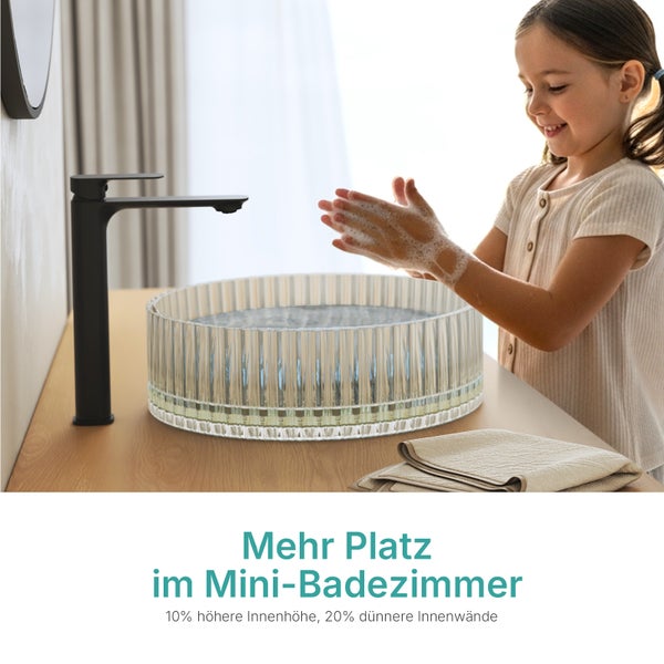 Ein Mädchen wäscht sich die Hände in einem transparenten Waschbecken mit schwarzer Armatur in einem Badezimmer