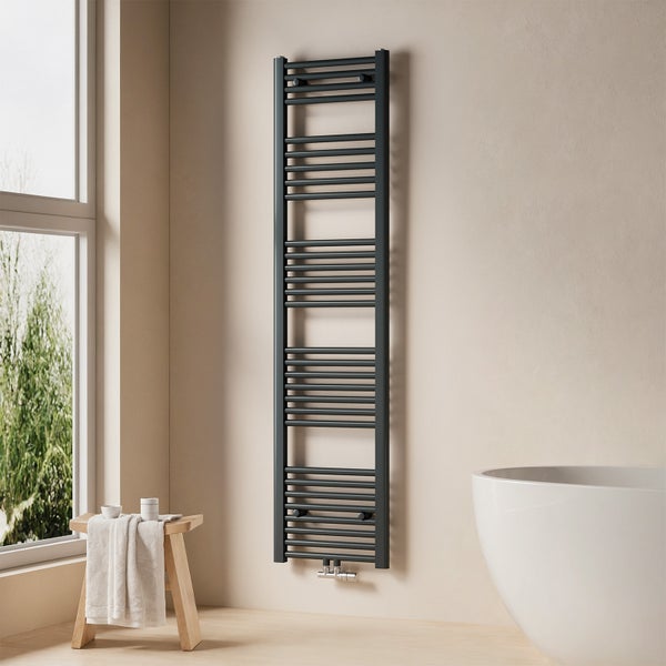 Badezimmer mit Handtuchwärmer, Badewanne und Hocker mit Handtüchern