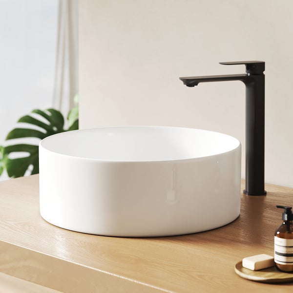 Aufsatzwaschbecken aus Keramik mit Armatur auf einer Holzplatte