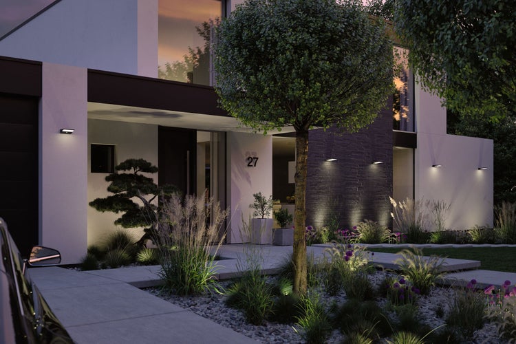 Moderne Hausfassade mit Aussenbeleuchtung, Gartenlandschaft und gepflastertem Weg