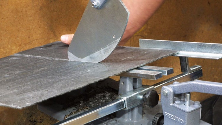 Schieferschere beim präzisen Schneiden einer Schieferplatte.