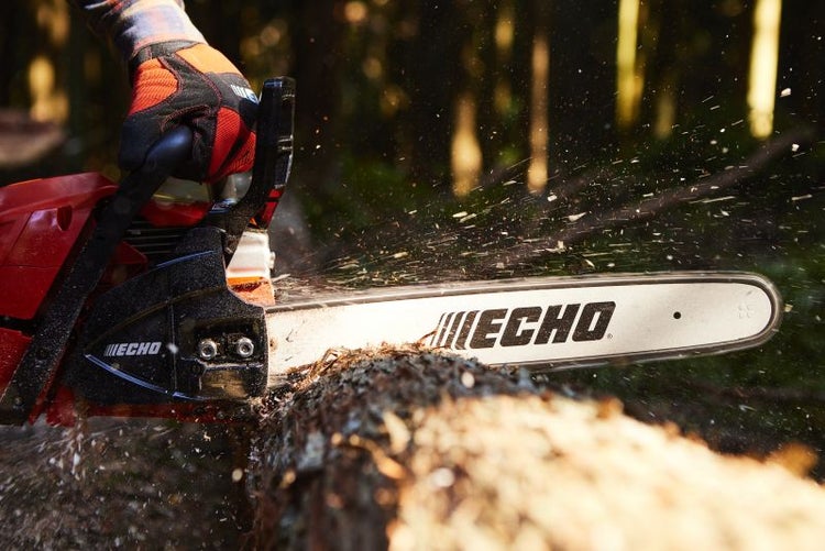 Eine Motorsäge schneidet einen Baumstamm mit Holzspänen. Auf der Motorsäge befindet sich das Echo Logo.