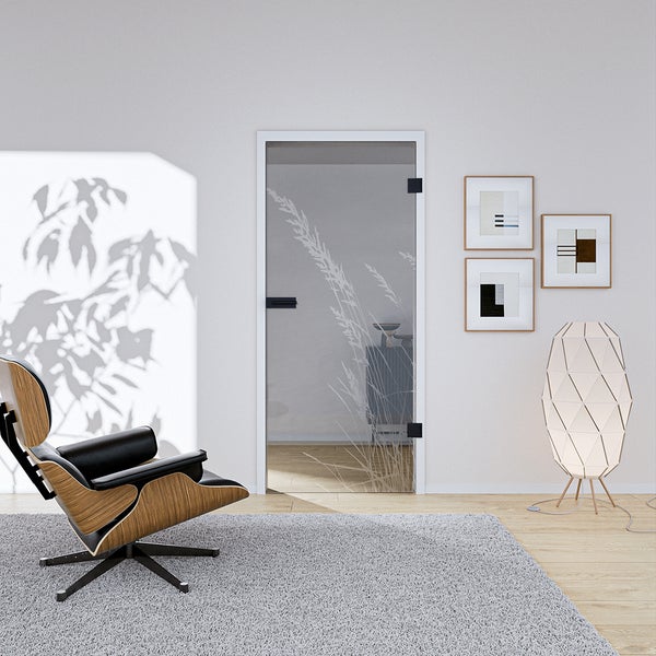 Ganzglastür mit Grasmotiv und Beschlägen in einem hellen, modern eingerichteten Wohnraum mit Sessel und Stehleuchte.
