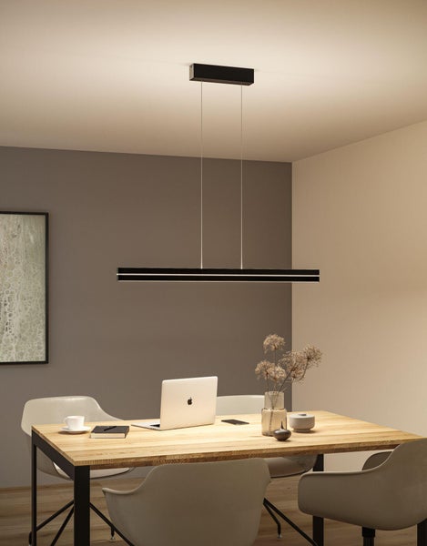 Moderne schwarze LED-Pendelleuchte in Balkenform über einem Holztisch mit Laptop in einem hellen, organisierten Innenraum.