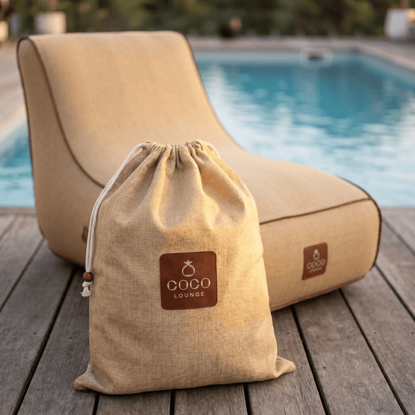 COCO LOUNGE Aufbewahrungsbeutel mit Kordelzug und passender Outdoor-Liegensitzsack auf einer Holzterrasse am Pool.