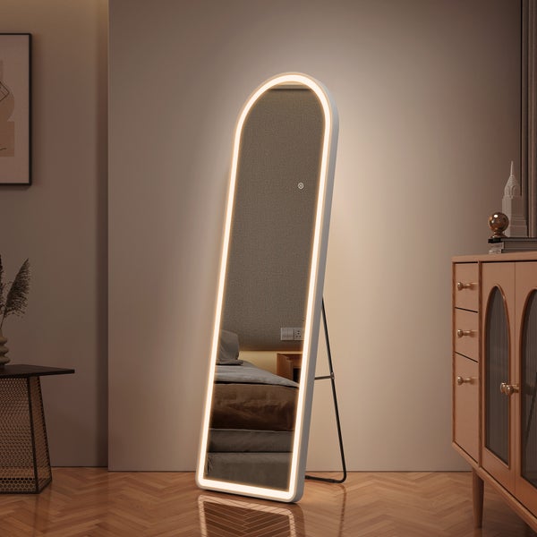 Modernes, helles Zimmer mit bogenförmigem Standspiegel mit LED-Beleuchtung, Parkettboden und Holzkommode.