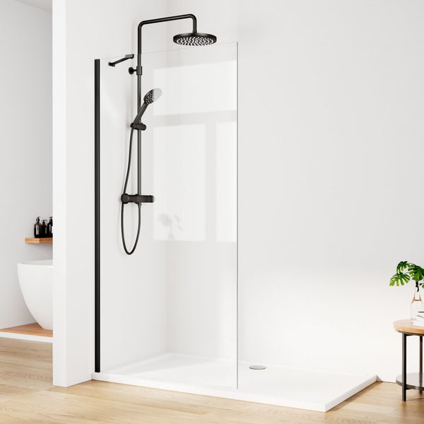 Begehbare Dusche mit Glaswand, flacher weißer Duschwanne und schwarzem Duschsystem inklusive Regendusche und Handbrause in hellem Badezimmer.