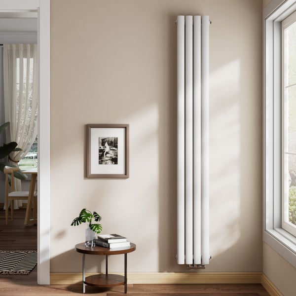 Vertikaler Designheizkörper mit runden Röhren in einem hellen Wohnzimmer neben einem Fenster und einem Beistelltisch montiert.