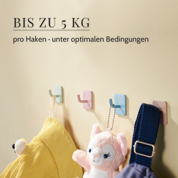 Mehrere bunte Wandhaken zum Kleben mit einer Tragkraft von bis zu 5 Kilogramm pro Haken an einer Wand montiert mit aufgehängten Gegenständen
