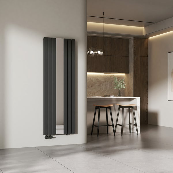 Vertikaler Design-Heizkörper mit integriertem Spiegel in einer modernen, hellen Wohnküche mit Barhockern und Holzschränken.