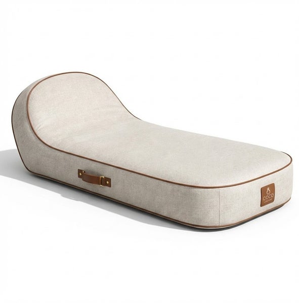 Ergonomisches Hundebett aus beigem Stoff mit brauner Lederpaspelierung, Tragegriff und Coco Maison Logo.