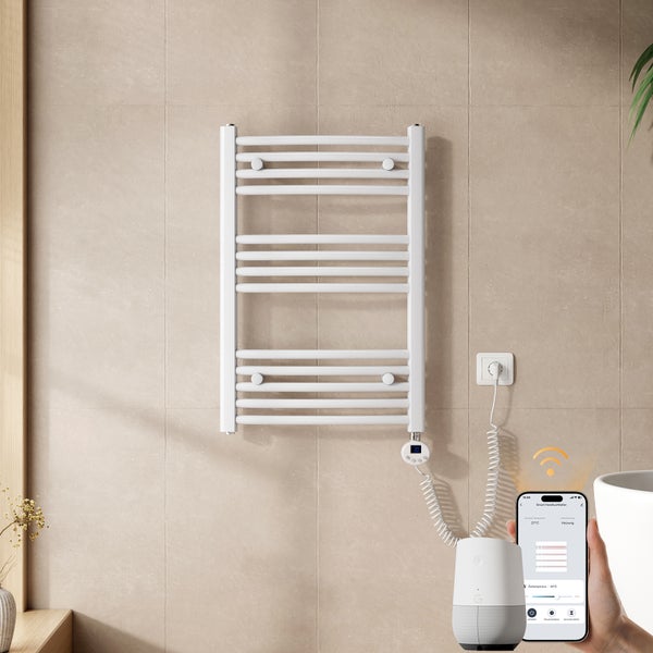 Elektrischer Handtuchheizkörper in einem Badezimmer, steuerbar über Smartphone-App und Smart Speaker, mit digitalem Thermostat.